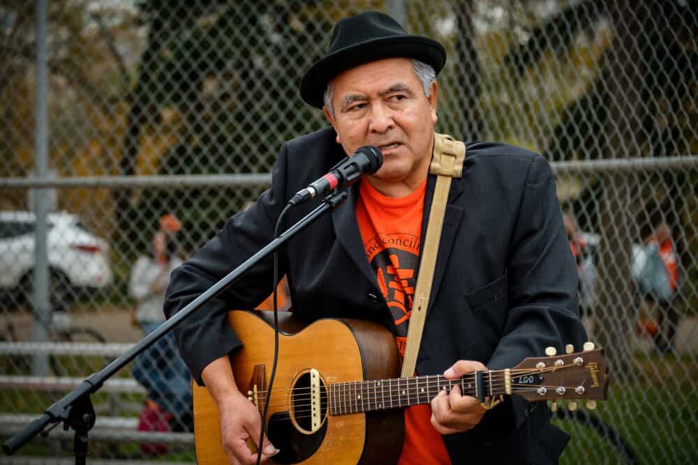Singer with Guitar Entertains Runners